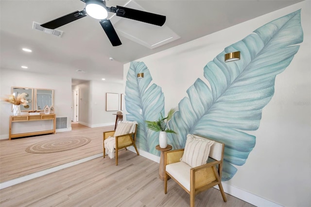 sitting room featuring visible vents, baseboards, and wood finished floors