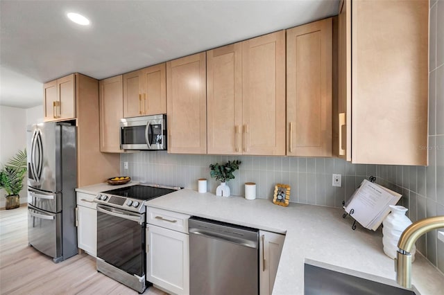 kitchen featuring decorative backsplash, appliances with stainless steel finishes, light countertops, light wood-type flooring, and light brown cabinets