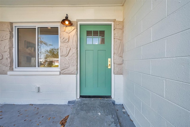 doorway to property featuring concrete block siding