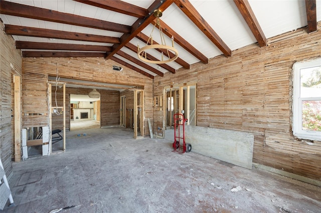 miscellaneous room featuring beam ceiling, high vaulted ceiling, and wood walls