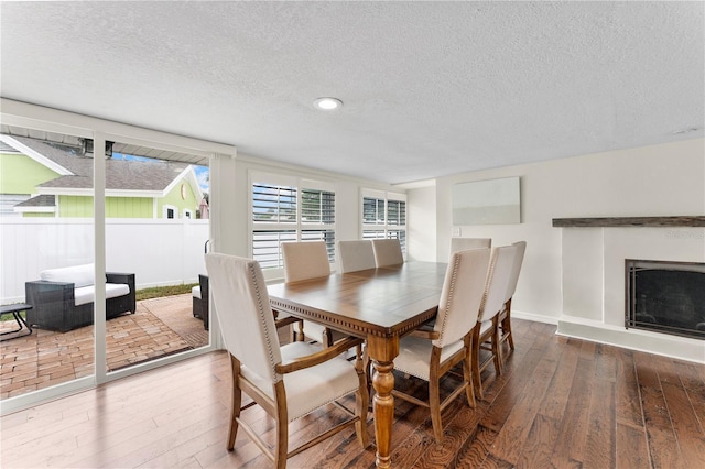 dining space with wood-type flooring and a textured ceiling