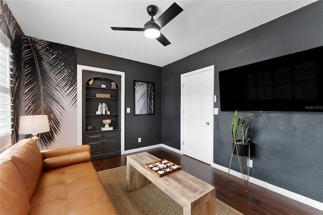 living room featuring ceiling fan, a healthy amount of sunlight, built in features, and dark hardwood / wood-style flooring