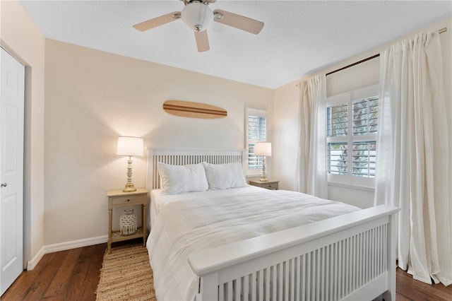 bedroom with dark hardwood / wood-style flooring and ceiling fan