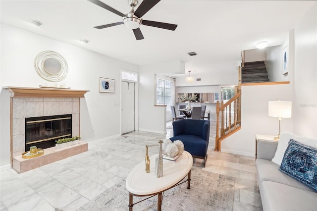 living room with ceiling fan and a fireplace