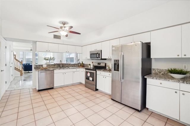 kitchen with light tile patterned flooring, sink, white cabinets, ceiling fan, and stainless steel appliances