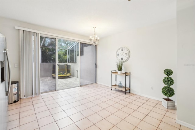 spare room featuring light tile patterned floors and a chandelier