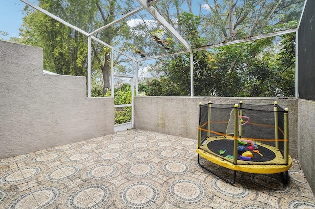 view of patio / terrace featuring glass enclosure and a trampoline