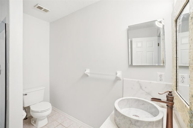 bathroom with toilet, tile patterned flooring, and sink