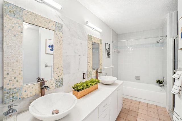 bathroom featuring vanity, tiled shower / bath combo, tile patterned floors, and a textured ceiling