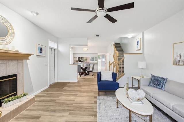 2794 Countryside Blvd Unit 1, Clearwater, FL 33761 - living area featuring stairway, a ceiling fan, wood finished floors, and a fireplace