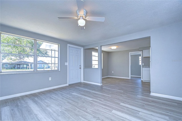 empty room featuring ceiling fan, wood-type flooring, and a textured ceiling