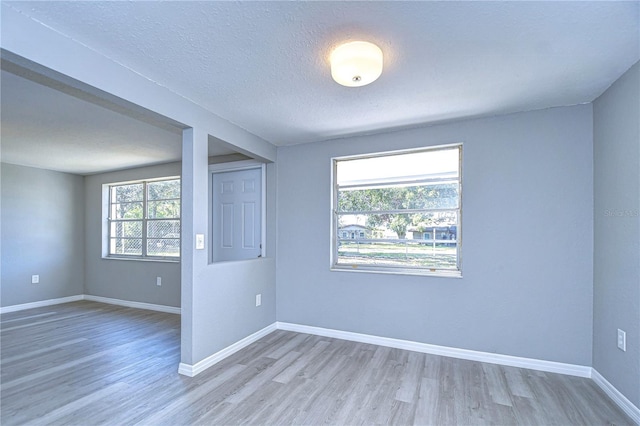 unfurnished room with hardwood / wood-style floors and a textured ceiling