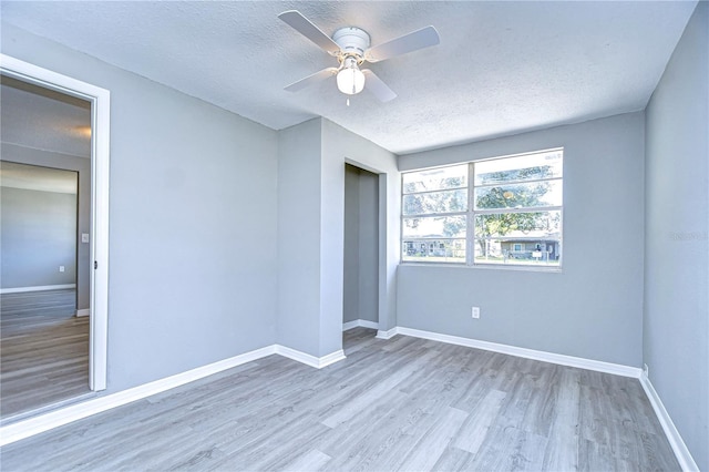 empty room with hardwood / wood-style flooring, a textured ceiling, and ceiling fan