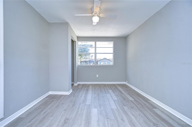 unfurnished room with ceiling fan, light hardwood / wood-style flooring, and a textured ceiling