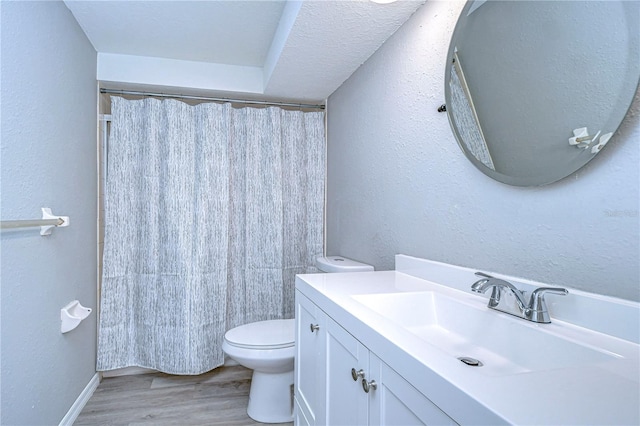 bathroom with toilet, a shower with curtain, a textured ceiling, vanity, and hardwood / wood-style flooring