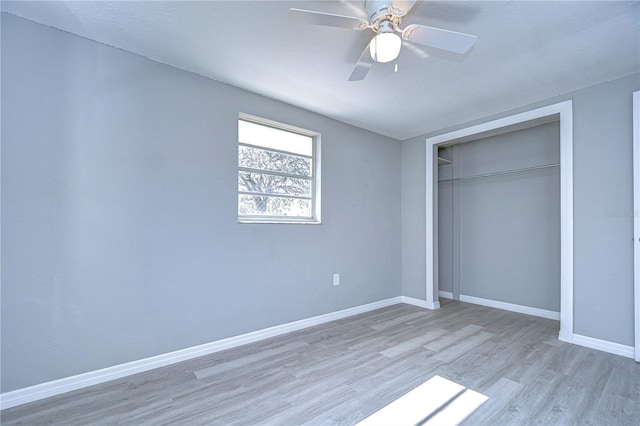 unfurnished bedroom featuring light wood-type flooring, ceiling fan, and a closet