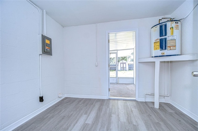 laundry area with electric water heater, electric panel, and light wood-type flooring