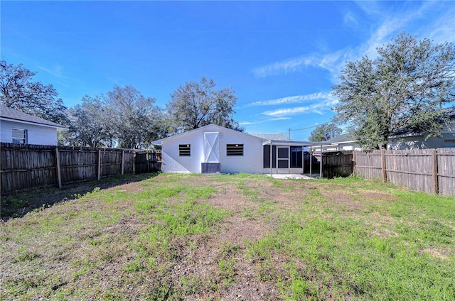 back of house with a sunroom and a yard