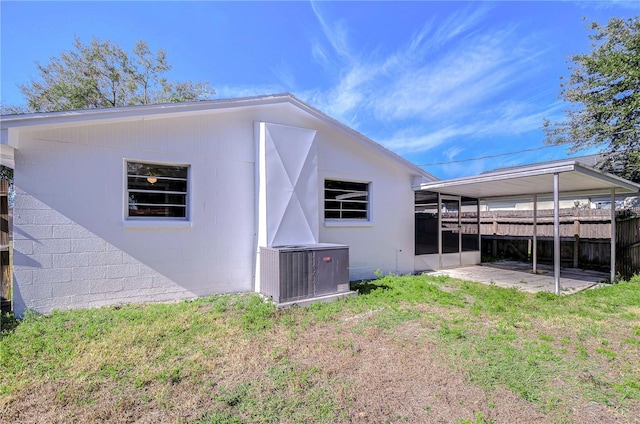 rear view of house with a yard and central AC