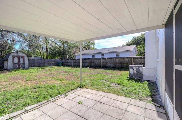 view of yard featuring a shed, a patio, and central air condition unit