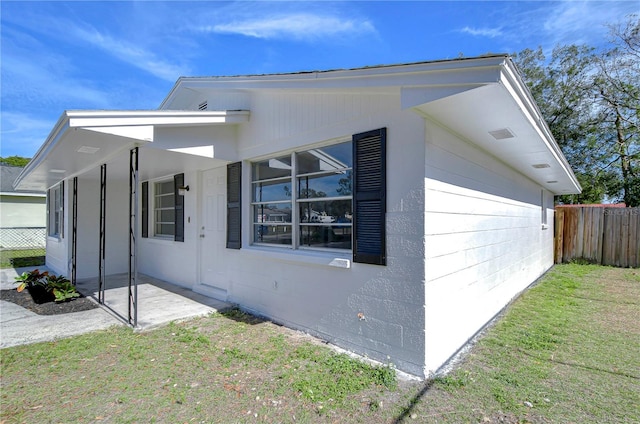 view of property exterior with a yard and a patio area