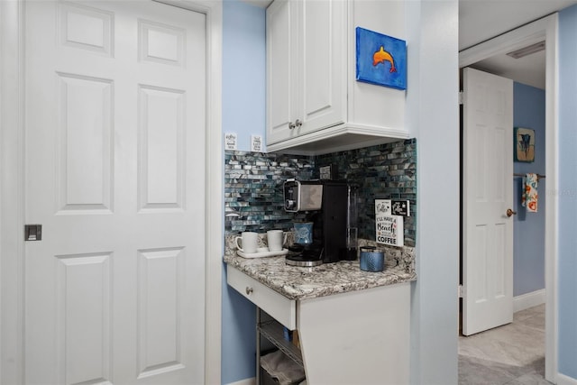 bar with light tile patterned floors, tasteful backsplash, and baseboards