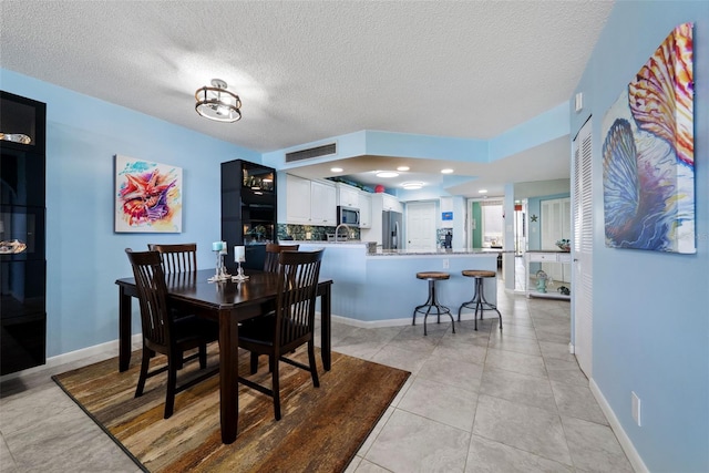 dining room with a textured ceiling, light tile patterned flooring, recessed lighting, visible vents, and baseboards