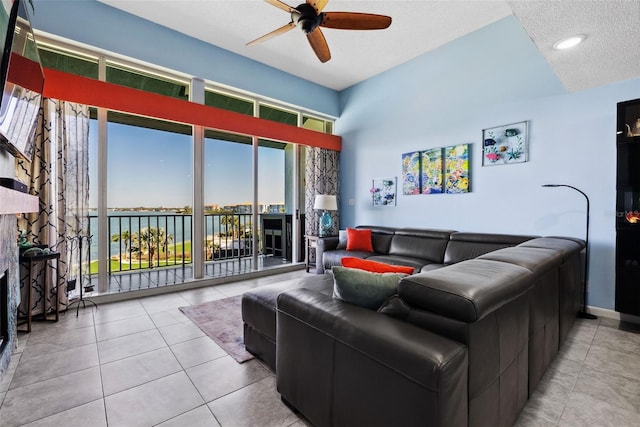 tiled living area with a fireplace, baseboards, and a ceiling fan