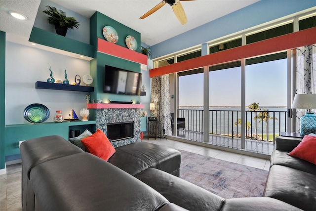 living room with ceiling fan, a fireplace, and tile patterned floors