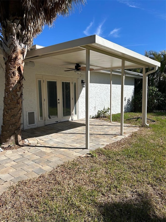 rear view of property featuring french doors, ceiling fan, a yard, and a patio area