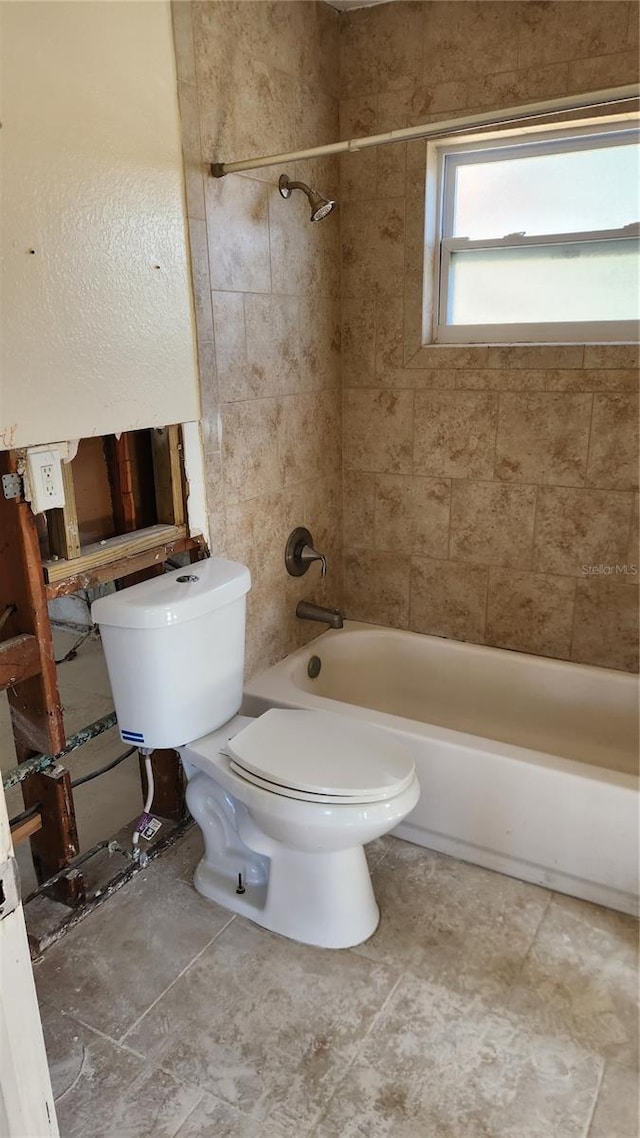 bathroom with toilet and tiled shower / bath combo