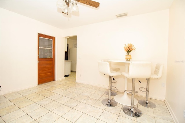 unfurnished dining area featuring light tile patterned floors and ceiling fan