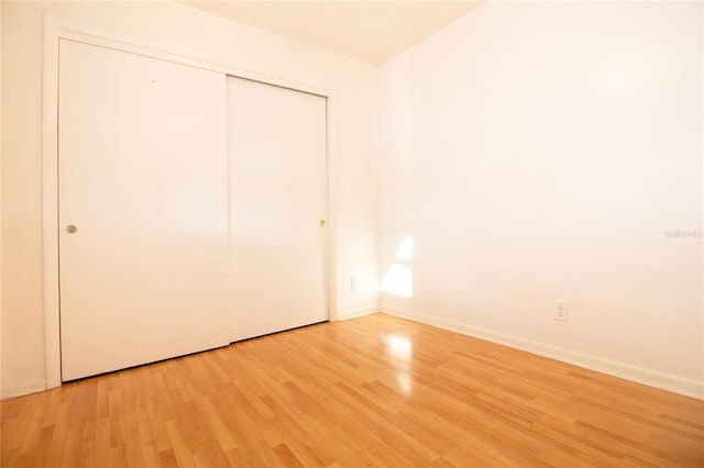 unfurnished bedroom featuring a closet and light wood-type flooring