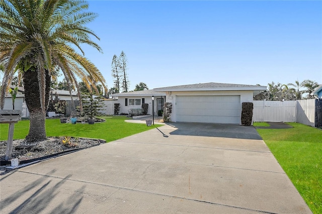 single story home featuring a garage, stucco siding, fence, a front lawn, and driveway