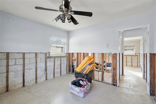 spare room featuring ceiling fan and wainscoting