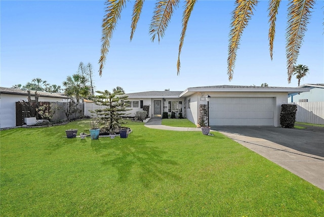 view of front of house featuring concrete driveway, stucco siding, an attached garage, a front yard, and fence