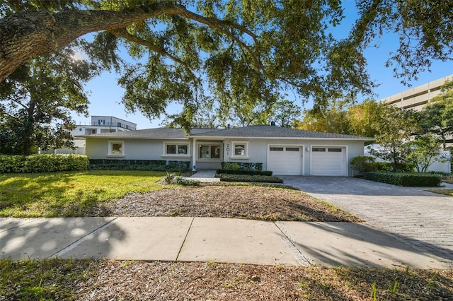 ranch-style house featuring a garage and a front lawn