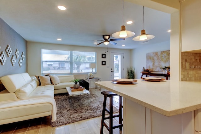 living room featuring light hardwood / wood-style flooring and ceiling fan