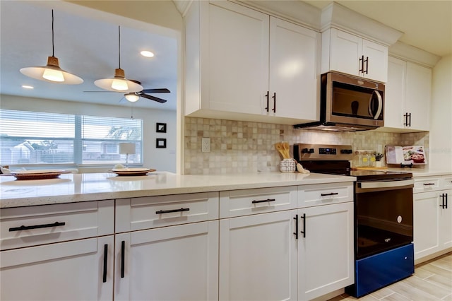 kitchen featuring white cabinetry, stainless steel appliances, tasteful backsplash, and pendant lighting