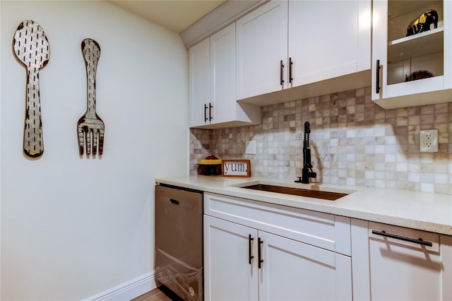 kitchen with sink, dishwasher, light stone countertops, decorative backsplash, and white cabinets