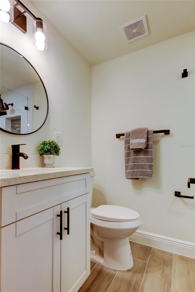 bathroom with vanity, wood-type flooring, and toilet