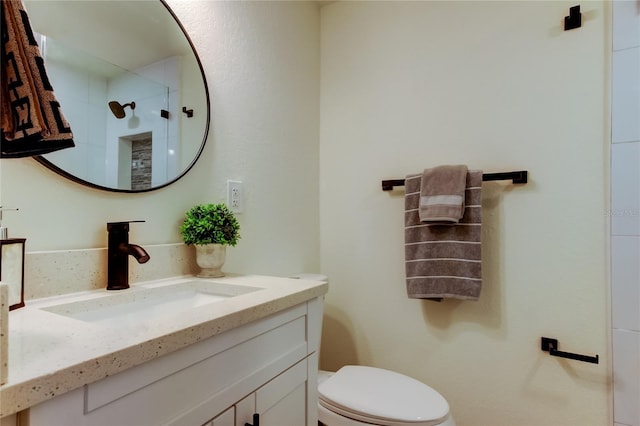 bathroom featuring vanity, a shower, and toilet