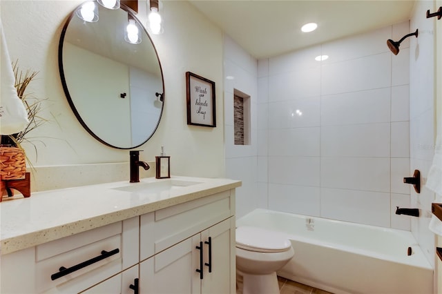 full bathroom featuring vanity, tiled shower / bath, and toilet