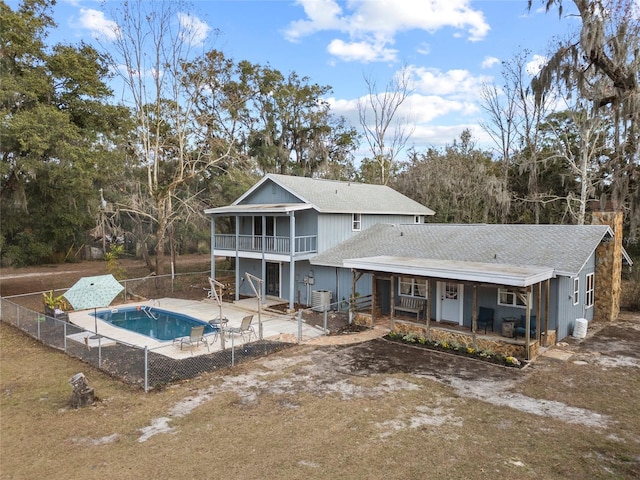 back of house featuring a fenced in pool, a patio area, a sunroom, and central air condition unit