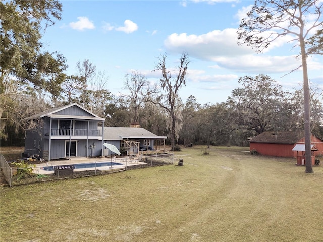 view of yard with a pool, a sunroom, and a patio