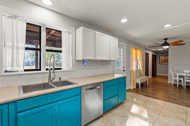 kitchen with sink, blue cabinetry, tasteful backsplash, white cabinets, and stainless steel dishwasher