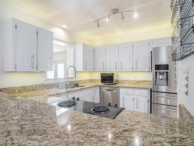 kitchen featuring light stone counters, stainless steel appliances, sink, and white cabinets