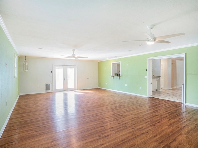 spare room with ornamental molding, french doors, ceiling fan, and light wood-type flooring