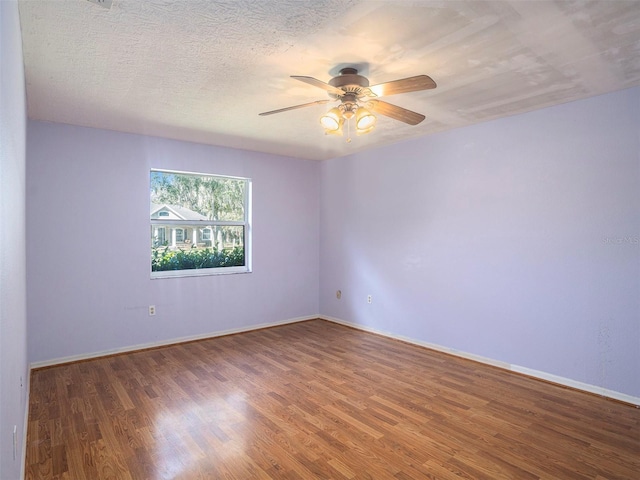 unfurnished room featuring ceiling fan, a textured ceiling, and dark hardwood / wood-style flooring