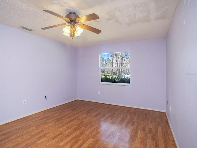 unfurnished room featuring ceiling fan, hardwood / wood-style flooring, and a textured ceiling